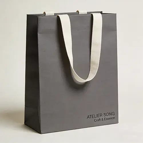 Gray kraft paper bag with ribbon handle and black logo